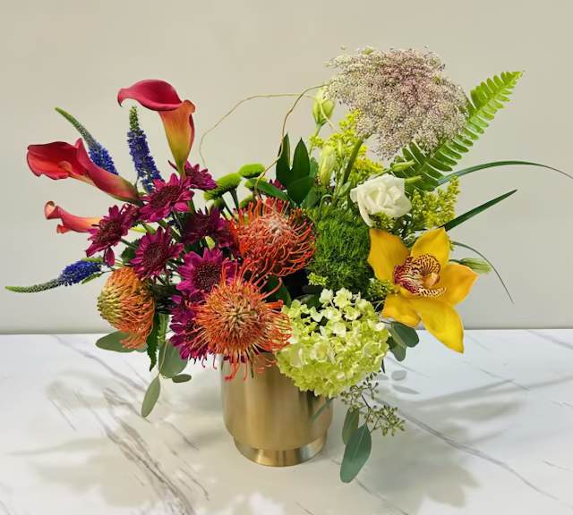 Golden Pop Golden Pop - Golden Pop is a vibrant mix of colorful blooms in a sleek golden vase, creating a bold and modern statement. It adds a burst of energy and elegance to any space or occasion.