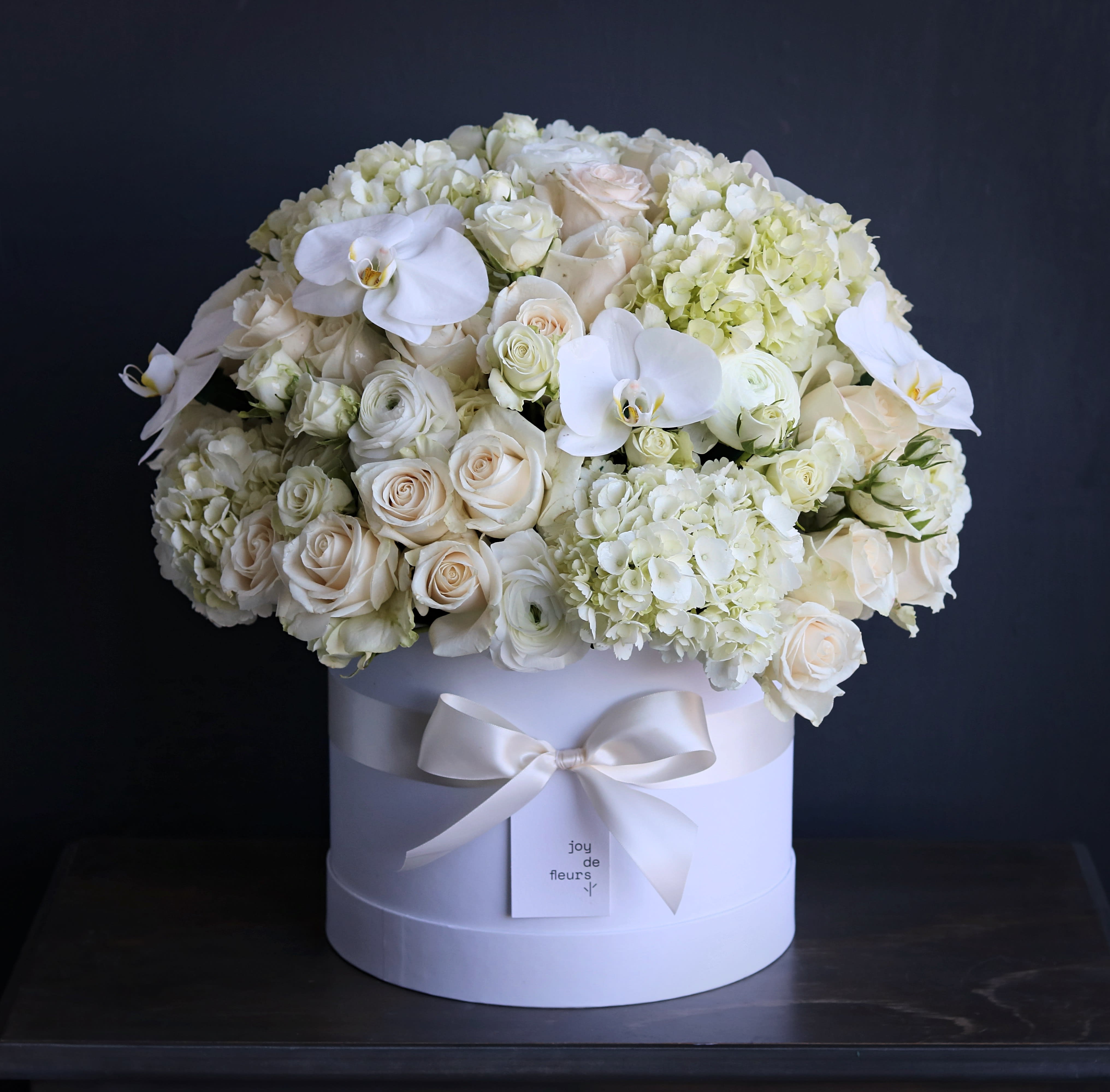 mixed florals box - This luxury arrangement contains mixed florals such as roses, ranunculuses, anemones, garden roses, peonies, and others, beautifully laid out in a handcrafted 10&quot; box with satin ribbon. Handwritten card is included. Send the most beautiful flowers for that special someone. Next day delivery available to Tequesta, Jupiter, Palm Beach Gardens and Palm Beach.   At checkout please indicate in florist instructions if you prefer a white or black box as well as the color of the main florals.
