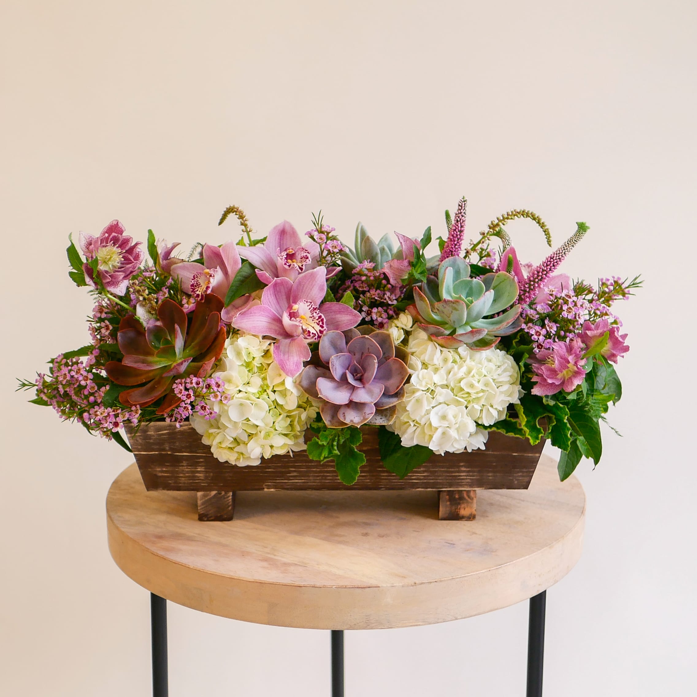 Succulent Romance - This unique arrangement features a lush collection of long-lasting flowers, such as succulents and elegant orchids. Crafted with meticulous attention to detail, this captivating arrangement is one of our most popular sellers! Arrangement will be delivered approximately as pictured, about 18 inches long and 8 inches wide with flowers.