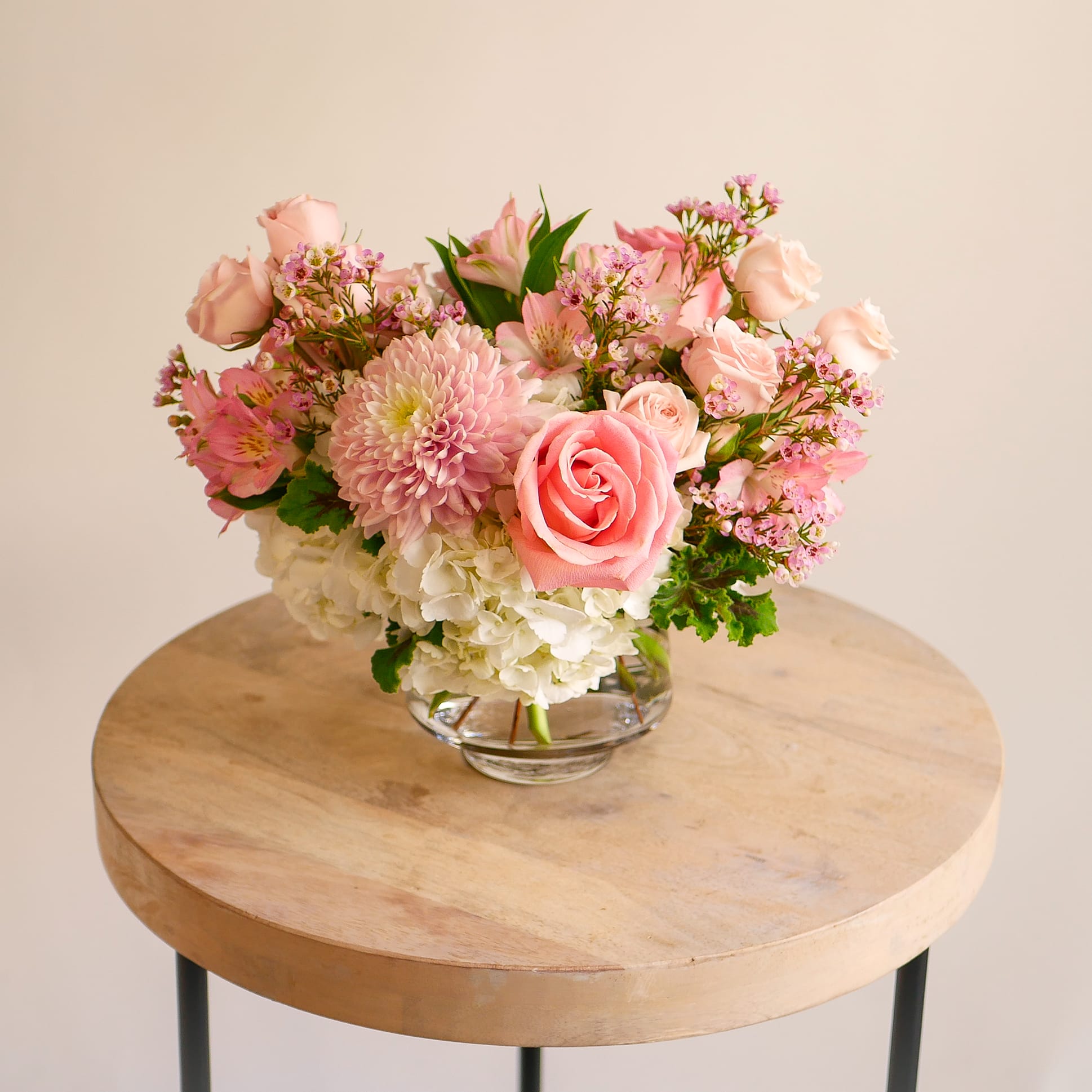 Lovely Linette - Delicate and charming, this arrangement showcases soft pink blooms such as roses, mums, alstroemeria, waxflower, complemented by lush white hydrangeas and accents of fresh greenery. Artfully designed in a modern glass vase, it’s the perfect gift for celebrating love and life's special moments. Arrangement approximately measures 11&quot; inches tall and wide with flowers.