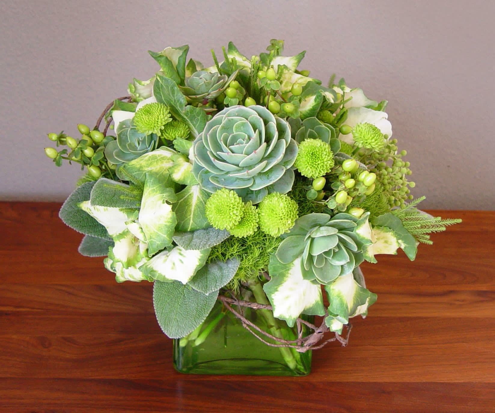 Lime Drops - A lime green arrangement that includes succulents, kale and lemon leaves arranged in a square crystal vase. 