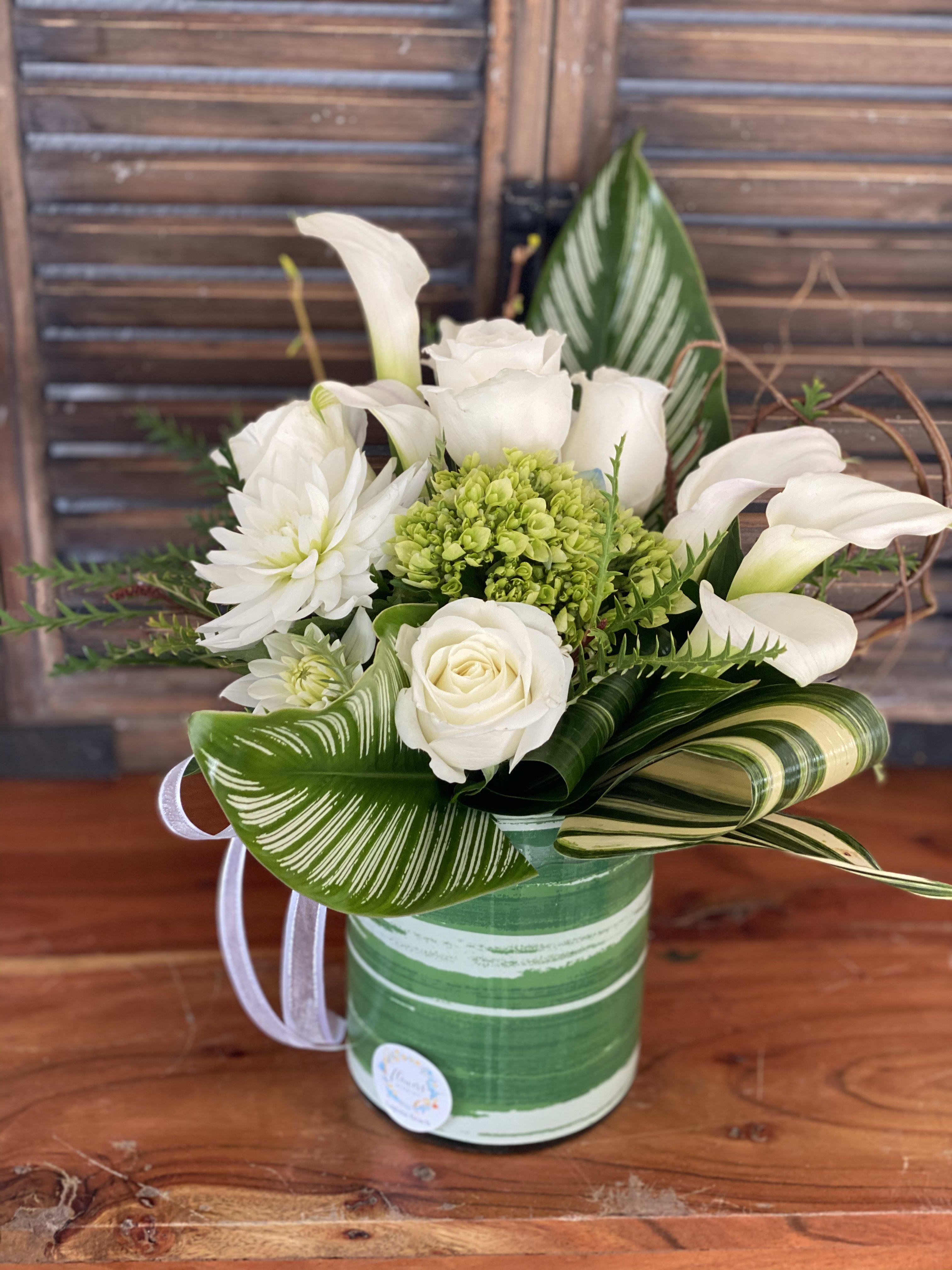 White love  - Center piece in tropical leaves and traditional white roses.