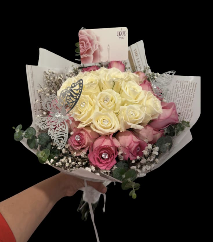 Princess’s Romance Bouquet - Princess’s Romance Bouquet  Delicate, enchanting, and truly magical, our Princess’s Romance Bouquet is the perfect expression of love and elegance. This captivating arrangement features soft white and pink roses, complemented by the graceful touch of eucalyptus and airy baby’s breath, creating a dreamy and romantic ambiance.   Wrapped in luxurious Korean paper and adorned with metallic butterflies, this bouquet radiates an enchanting, fairy-tale quality. Each rose is delicately embellished with sparkle stones, adding a touch of glamour and elegance that makes this bouquet truly one-of-a-kind.  Romantic. Whimsical. Magical. The ideal bouquet for the princess in your life, designed to dazzle and captivate with its beauty and charm. 