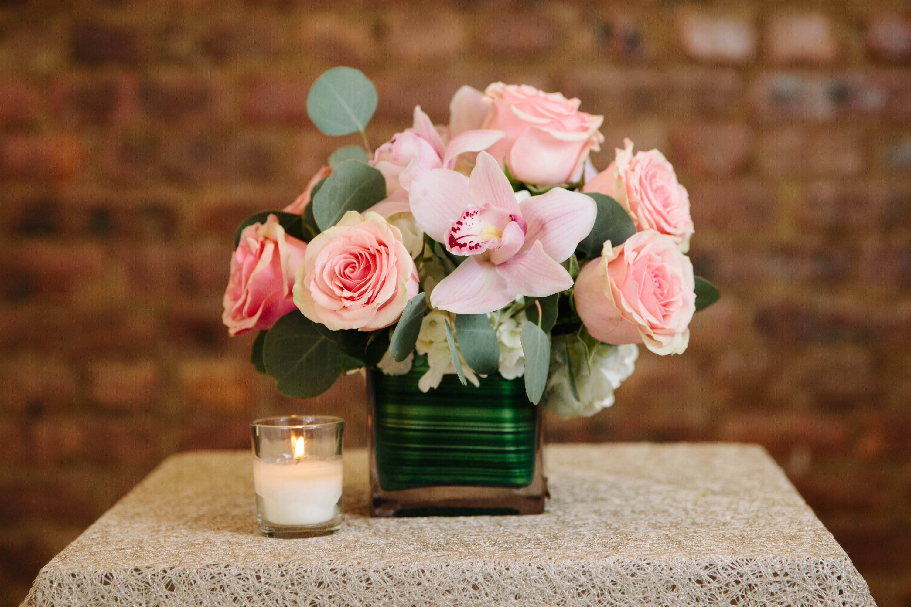 Pink Lady Pink Lady - A gorgeous arrangement of lush pink roses and pink cymbidium orchid blooms accented with decorative silver dollar eucalyptus and arranged in a square vase.