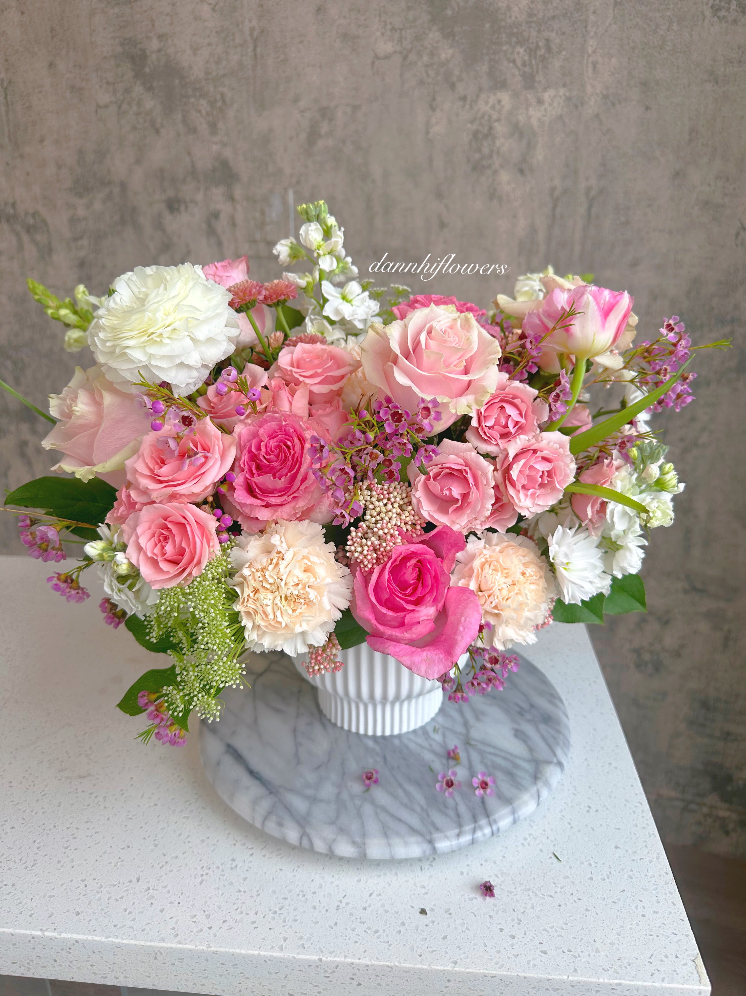 Pink footage . - Pink and white arrangement in a stylish footed ceramic vase. Photo is Standard size. Deluxe size will be slightly bigger.  *Vase may be substituted with a similar style depends on current stock.