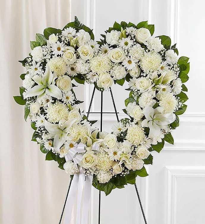 Dewdrop Delight - Elevate any occasion with this exquisite heart-shaped arrangement featuring elegant white lilies, classic white roses, delicate white carnations, and a touch of baby’s breath. A truly timeless bouquet that speaks the language of love and sophistication.