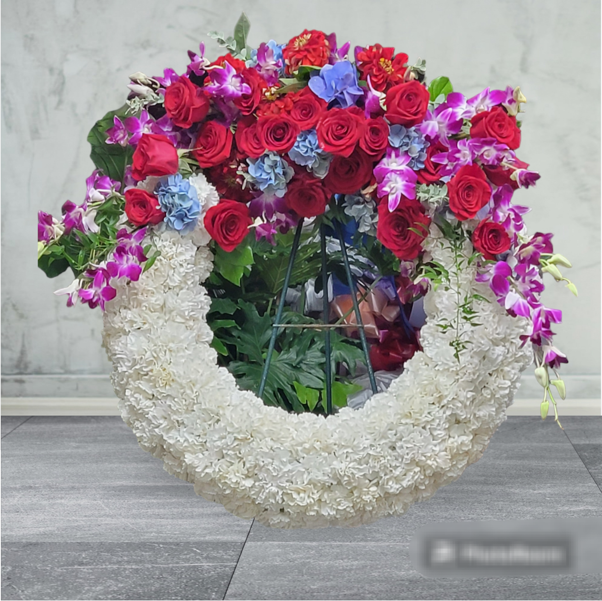 Strength of Glory Wreath Strength of Glory Wreath - White Carnations, red roses, blue hydrangea, purple dendrobium