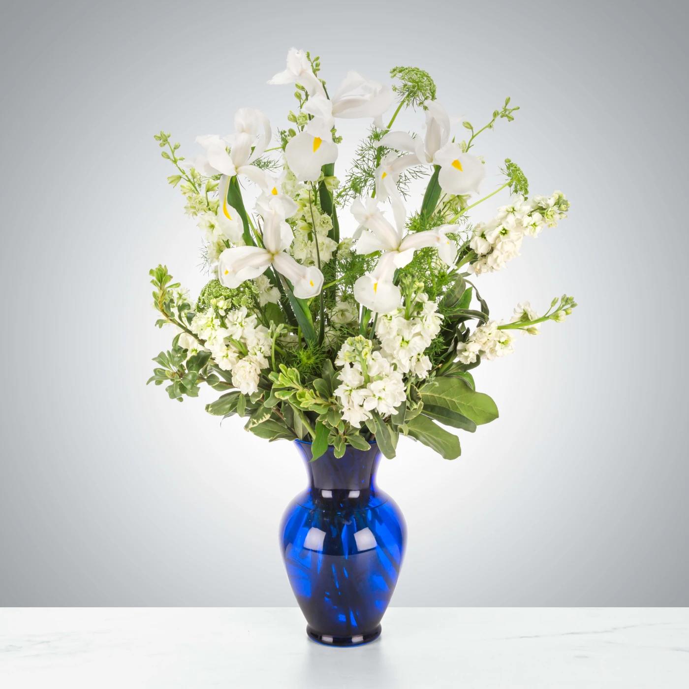 Crystal Symphony by BloomNation™ Crystal Symphony by BloomNation™ - This arrangement includes white iris, white stock, white snapdragons, and queen anne's lace in a blue vase. Send your condolences with Crystal Symphony by BloomNation™™. Approximate Dimensions: 22"D x 30"H