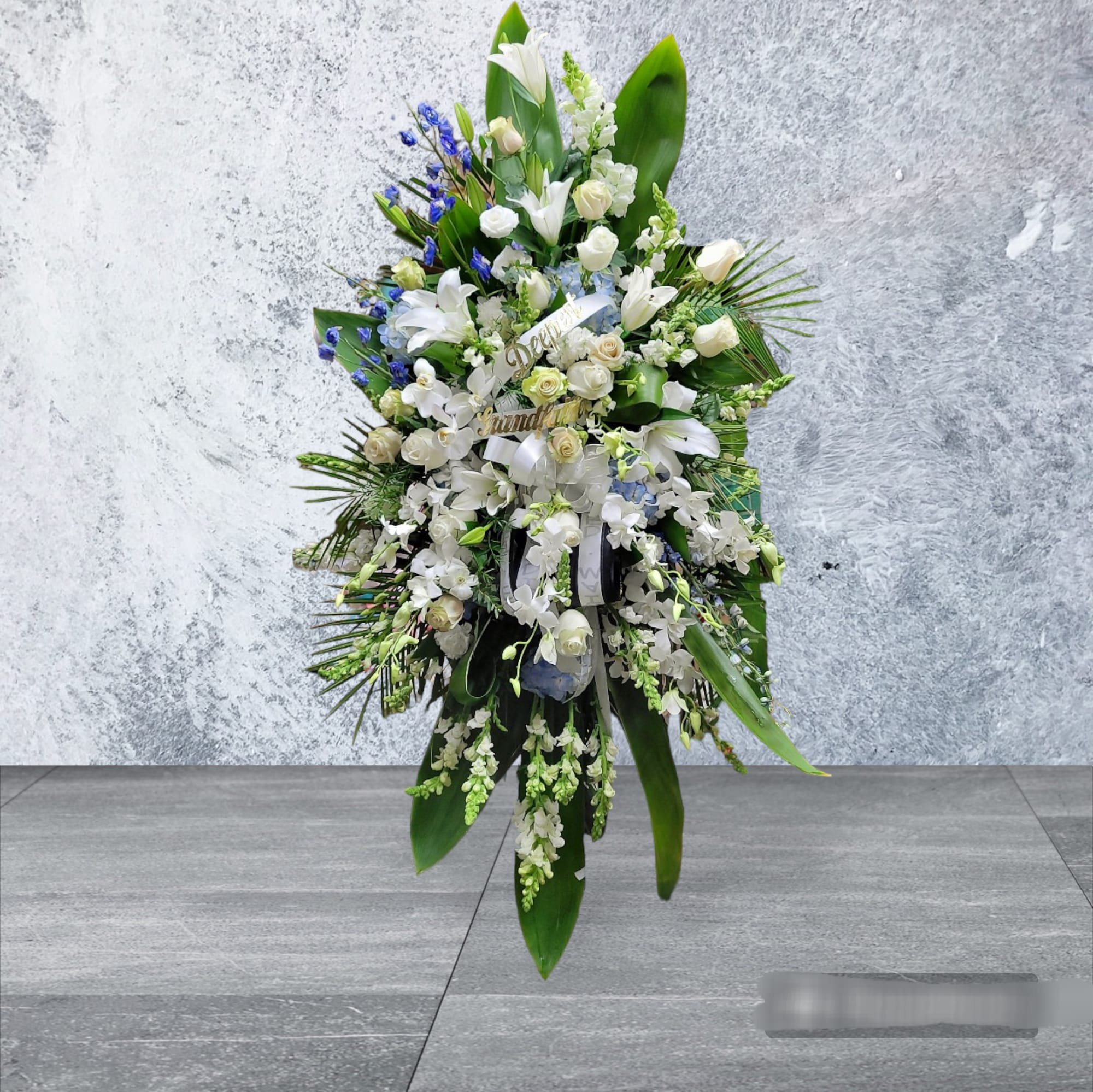 Farewell Spray Farewell Spray - Blue hydrangea,blue delphinium, white roses, white oriental lilies, white snapdragon, white dendrobium, ti leaves, and lemon leaf