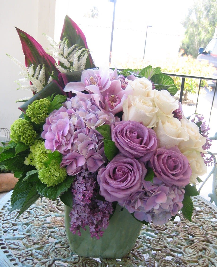 Lavander Dream - Elegant combination of lavander and cream color roses with Hydrangeas, Lilace, Cymbidium orchids, Kale Ti Leaves and other unique flowers.