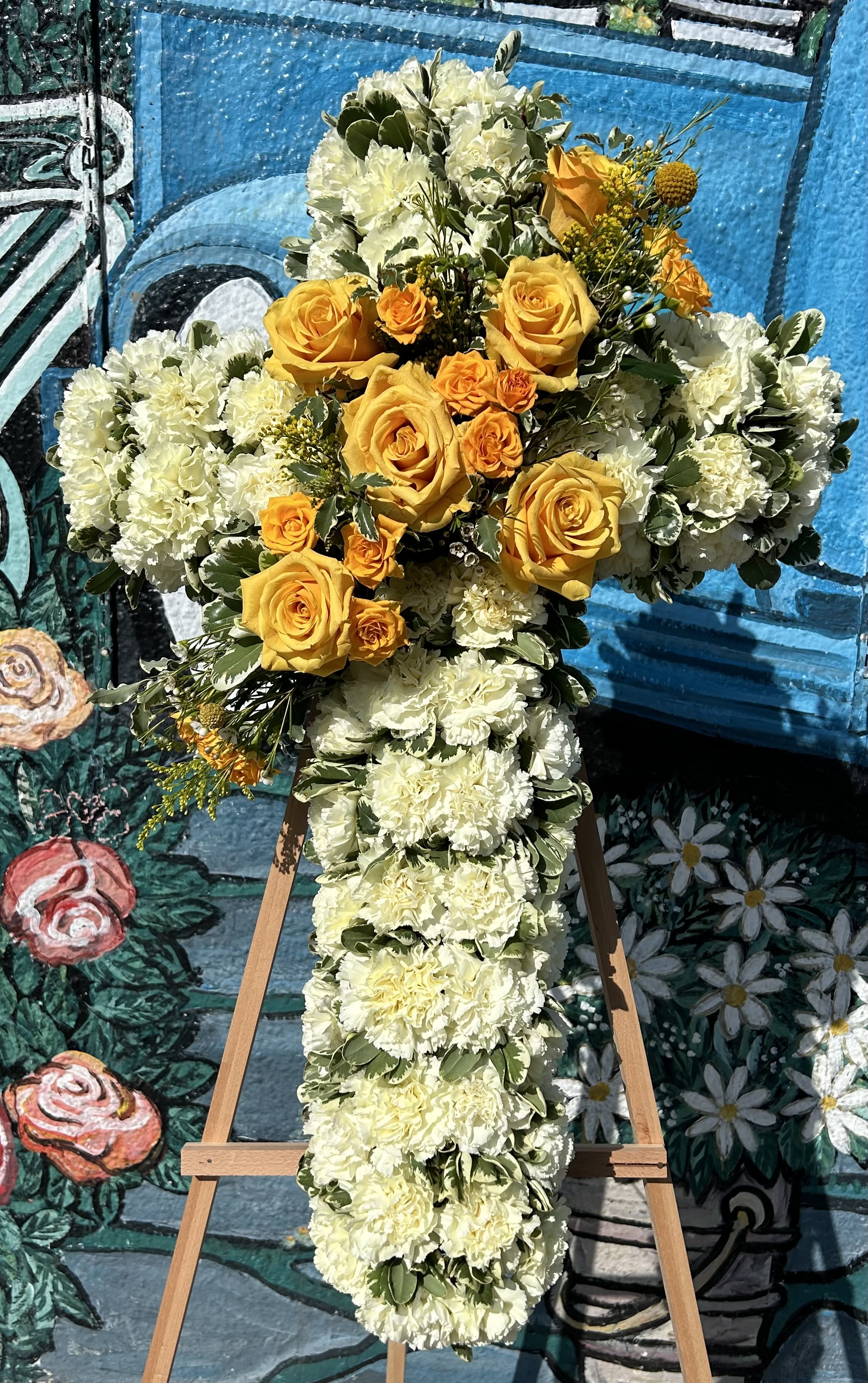 Carnation Cross Carnation Cross - White carnations with seasonal fillers in the middle of the cross. *If you'd like a different color scheme in the middle of the cross, please let us know*