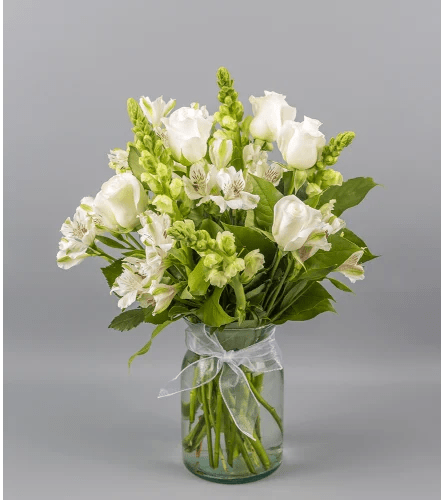 Crisp Whites by DGlamour PineCrest Flowers TM Crisp Whites by DGlamour PineCrest Flowers TM - Introducing our elegant Crisp White Floral Arrangement, a timeless blend of sophistication and purity. This stunning arrangement features pristine white snapdragons, delicate white alstroemerias, and velvety white roses, meticulously arranged to create a harmonious display of serenity. Adorned with a subtle touch of refinement, a small white ribbon completes the ensemble. Perfect for any occasion, this all-white floral masterpiece effortlessly radiates grace and beauty. Elevate your space with the purity of Crisp Whites.