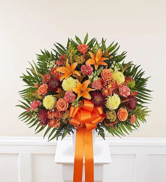 Heartfelt Sympathies™ Standing Basket - Fall - EXCLUSIVE The loss of a loved one is never easy, but a caring gesture can provide comfort and hope. Our classic standing basket arrangement is crafted by local florists with an abundance of blooms in rich, autumn colors. It’s a touching tribute to remind family and friends that brighter days are ahead.  Standing basket arrangement with red cremons, orange roses, Asiatic lilies and carnations, yellow football mums and snapdragons, bronze daisy poms; accented with assorted greenery and an orange ribbon Large measures approximately 34&quot;H x 37.5&quot;W without stand Medium measures approximately 32&quot;H x 36&quot;W without stand Small measures approximately 30&quot;H x 34&quot;W without stand Appropriate for the funeral home Metal tand is based on local availability Our florists hand-design each arrangement, so colors and varieties may vary due to local availability To ensure lasting beauty, lilies may arrive in bud form and will fully bloom over the next few days