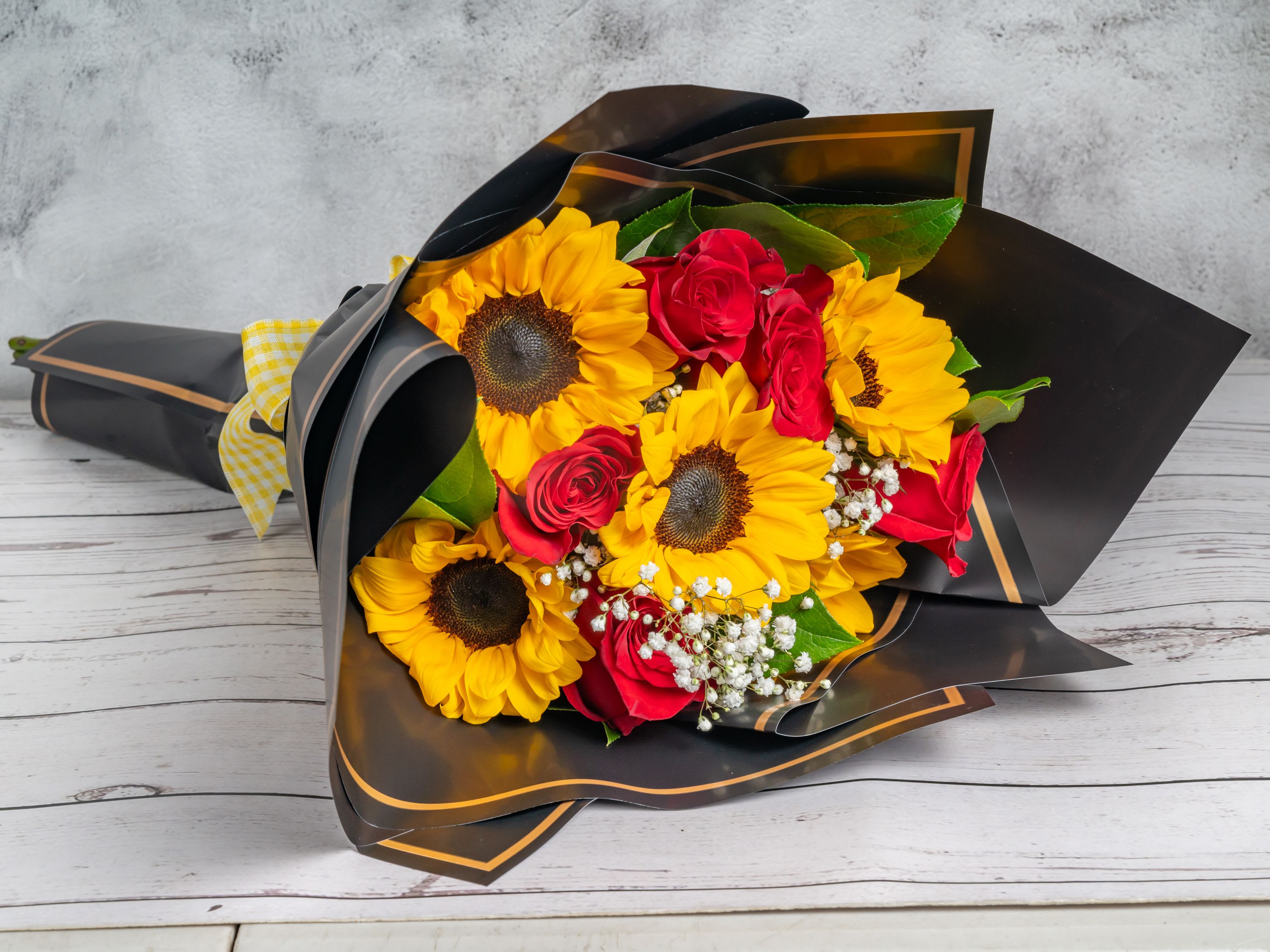 Golden Romance - A cheerful wrapped bouquet featuring vibrant sunflowers paired with elegant roses, creating a warm and sunny combination perfect for any occasion.