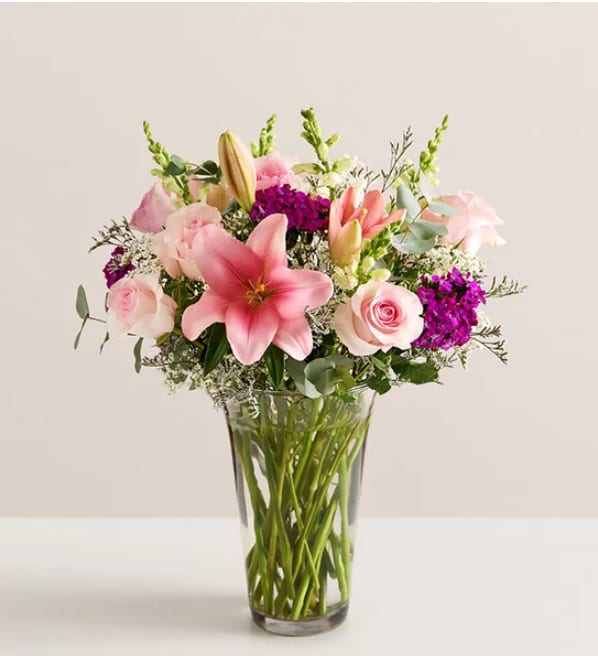 Marvelous Mom™ - A dazzling gathering of pink and purple, this bouquet will delight all the marvelous moms in your life. Our florists artistically arrange farm-fresh roses, Asiatic lilies, and other blooms to create a gift that expresses your love and appreciation in a way words never could.  All-around arrangement of pink roses and Asiatic lilies, purple dianthuses and limoniums, white snapdragons, baby’s-breath (gypsophila), and greenery Artistically designed in a clear glass vase; measures 12”H Premium arrangement measures approximately 23”H x 18”W Deluxe arrangement measures approximately 22”H x 14”W Standard arrangement measures approximately 21”H x 13”W Our florists hand-design each arrangement, so colors and varieties may vary due to local availability To ensure lasting beauty, Asiatic lilies may arrive in bud form and will fully bloom over the next few days