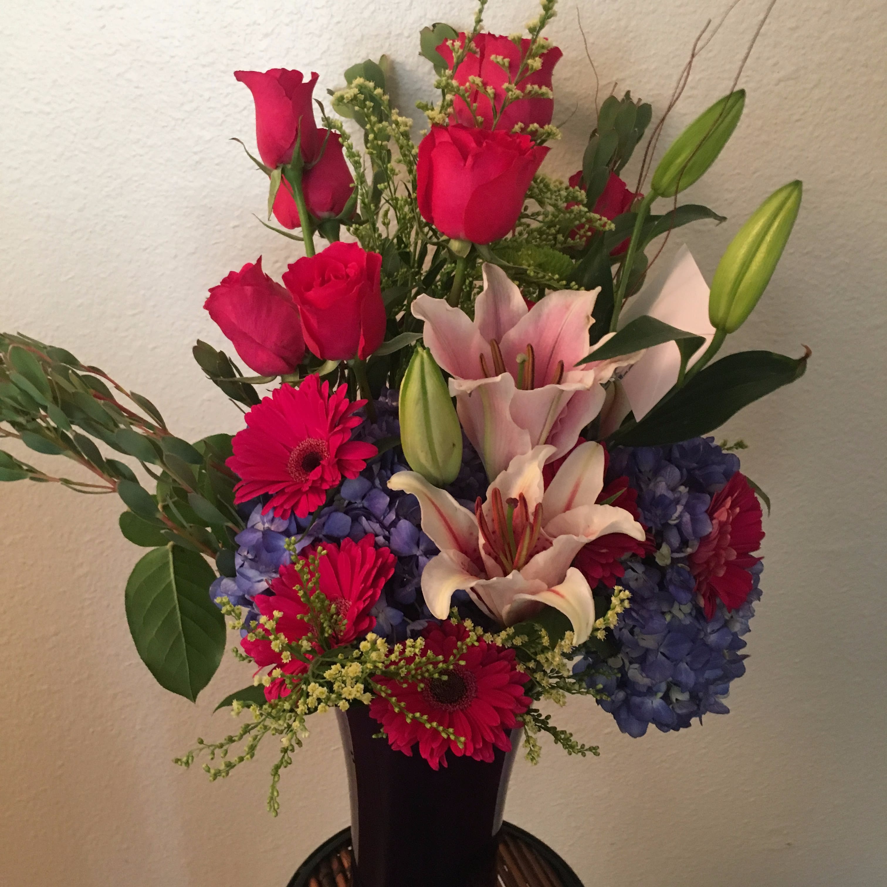 Blossoming Romance Blossoming Romance - A breathtaking arrangement of gerbera daisies and red roses mixed with fragrant stargazers and embedded in blue hydrengias makes for a very romantic way to express your love.