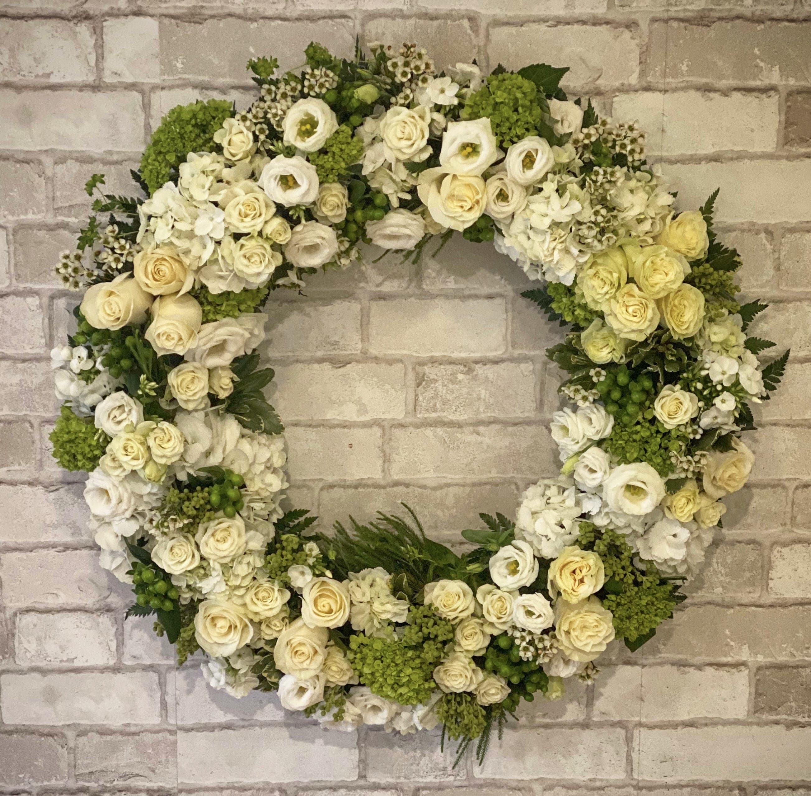 Elegant Sympathy Wreath (White) Elegant Sympathy Wreath (White) - A beautiful tribute of sympathy to those we have lost. Our "Elegant Sympathy Wreath" is one of our more substantial funeral pieces. Arranged with gorgeous greens and white premium blooms. Pictured here is our "Premium" model Appropriate for the service only. Standard - "18 Deluxe - 20" Premium- 24"