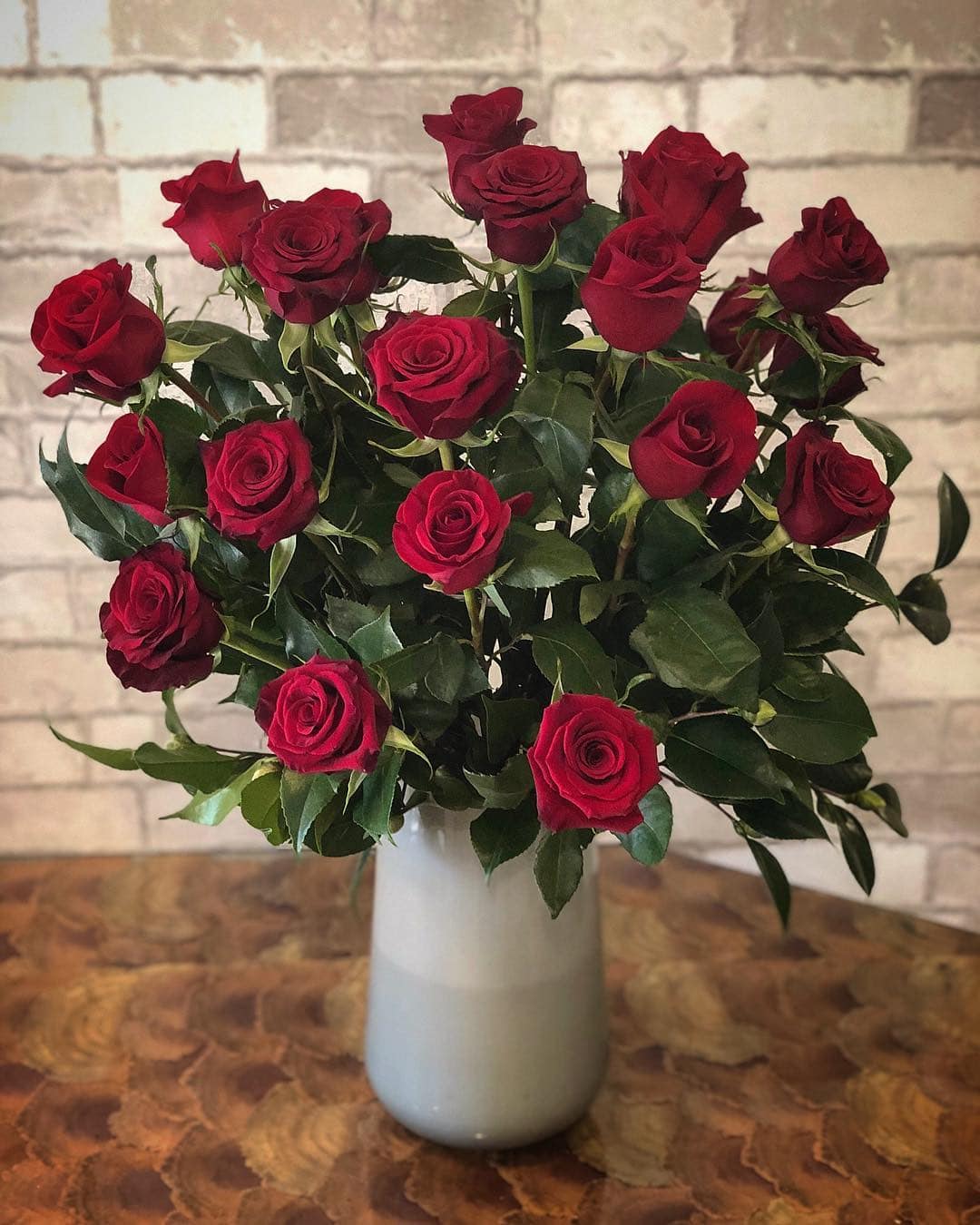 The Double Dozen The Double Dozen - Two dozen beautiful red roses arranged with lush greenery in a taller glass vase. The perfect show of affection for your special someone.