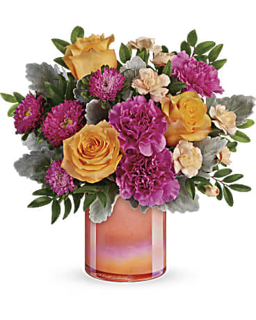 Teleflora's Perfect Spring Peach Bouquet Teleflora's Perfect Spring Peach Bouquet - Like a spectacular spring sunset, this radiant bouquet of oranges and pink blooms, presented in a peach glass vase with shimmering pearlized finish is sure to brighten anyone's day! This bouquet features peach roses, dark pink carnations, peach miniature carnations, hot pink matsumoto asters, dusty miller, and huckleberry. Delivered in Teleflora's Perfect Spring Peach cylinder. APPROXIMATE DIMENSIONS: 11 H - 11W STANDARD – $80.00 • 5 Hot Pink Carnations • 2 Pink Mini Carnations • 3 STANDARD orange roses • 2 Dusty Miller DELUXE– $95.00 • 5 Hot Pink Carnations • 2 Pink Mini Carnations • 5 STANDARD orange roses • 2 Dusty Miller PREMIUM– $110.00 • 5 Hot Pink Carnations • 2 Pink Mini Carnations • 7 STANDARD orange roses • 2 Dusty Miller