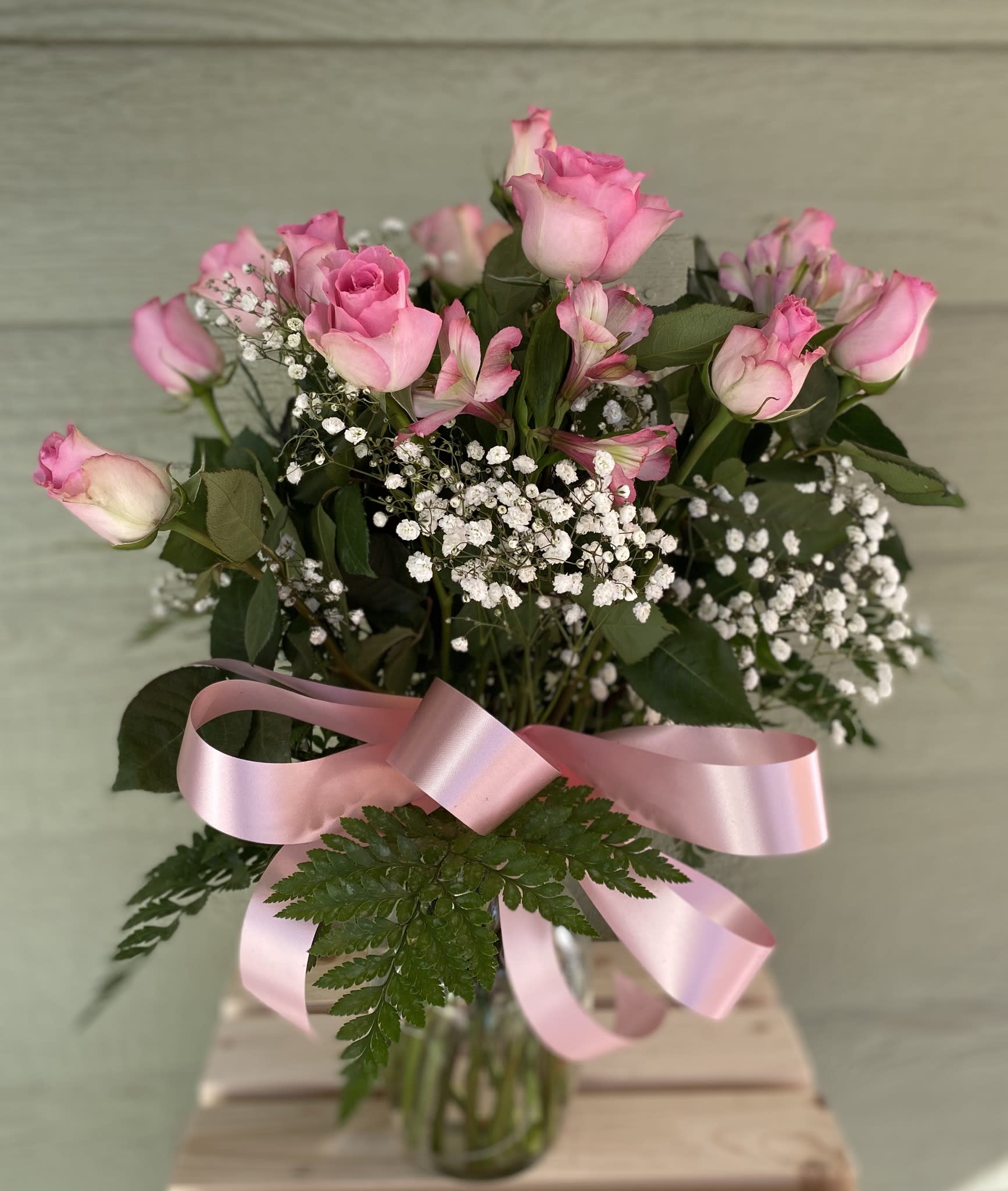 Dozen Pink Roses Dozen Pink Roses - Who doesn’t love a dozen pink roses arranged in a vase with babies breath and alstroemeria. The sweetest sentiment for your daughter or mom. Roses may vary from light pink to deep hot pink.