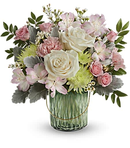 Teleflora's Lush Garden Teleflora's Lush Garden - Fresh from the garden, this special refreshing rose bouquet is arranged in a glorious sage green glass lantern with golden handle and embossed design. This arrangement features crème roses, pink spray roses, pink alstroemeria, pink carnations, green cushion spray chrysanthemums, white waxflower, dusty miller and huckleberry. This bouquet is delivered in Teleflora's Lush Garden Lantern, which can be used as a lovely votive or piece of décor. Approximately 13 1/2" W x 13 1/4" H The scale of the arrangement should determine the type of substitution acceptable, but the substitution must be of equal or greater value and must maintain the style and color harmony of the original order. Standard - 3 roses, 3 alrstro, 2 buttons, 3 carnations, 2 spray roses Deluxe - 5 roses, 3 alrstro, 2 buttons, 3 carnations, 2 spray roses Premium - 7 roses, 3 alrstro, 2 buttons, 3 carnations, 2 spray roses