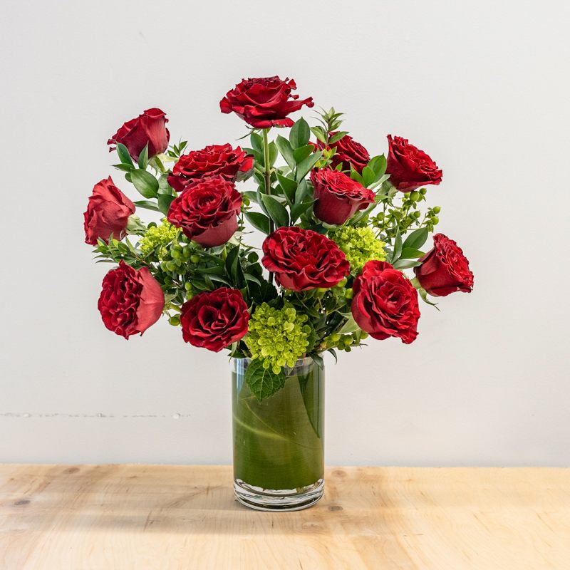 The Classic Dozen The Classic Dozen - There is nothing wrong with a good Classic! This classically arranged Dozen Roses are fresh cut, and spaced with luxury greenery. A scattering of green berries or monochromatic filler. Customer may request a color based on availability. Arrangement stands approximately 16" tall.