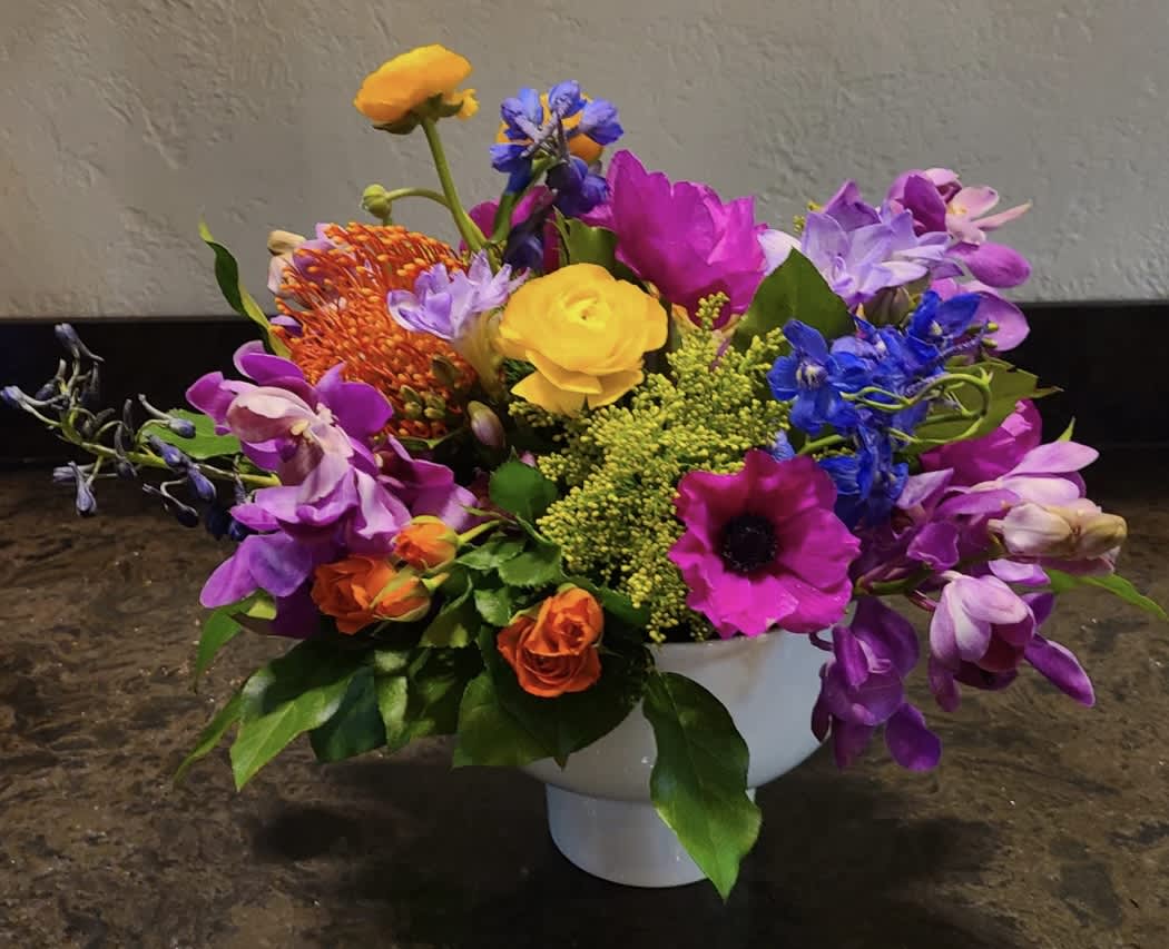 Atherton - The vibrancy in this design is sure to bring any tablescape to life. This arrangement features a variety of colors, textures and flowers uniquely designed every time.