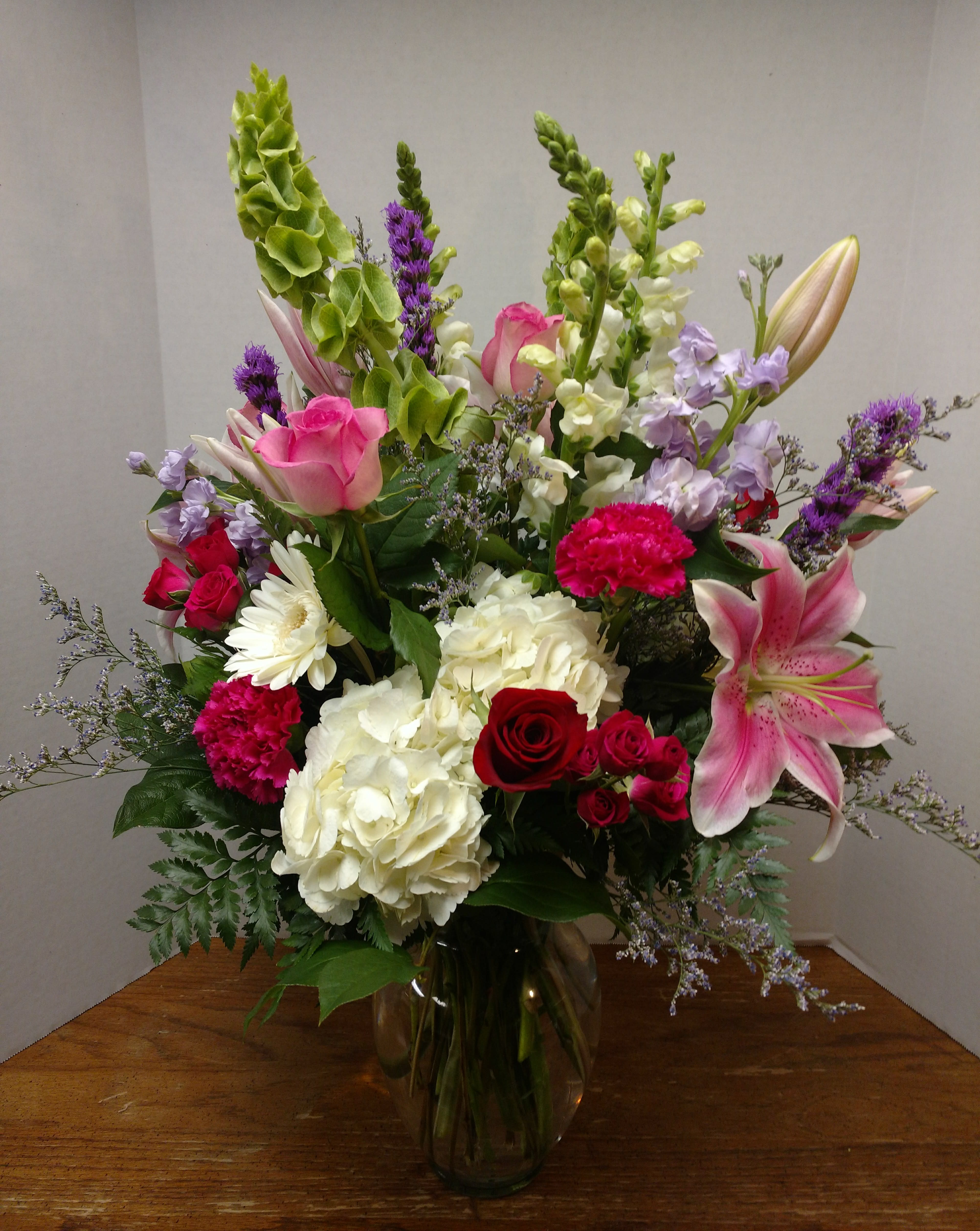 Show Stopper! by Candlelight and Roses - It's a garden in a vase, with everything nice!    Purples, pinks, red, whites.  Including snapdragon, stock, red &amp; pink roses, hydrangeas, lily's and more. Go ahead make a big impression with this Show Stopper!!
