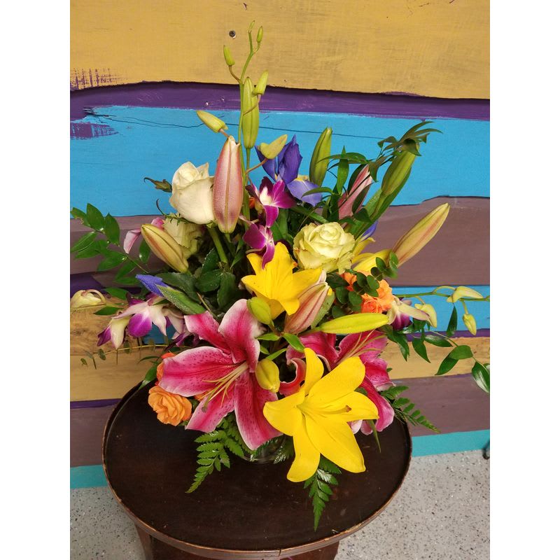 Colorful Delight - Bright colorful mix of fresh cut orchids, Roses, Stargazer Lilies, Iris Spray roses, and Asiatic Lilies arranged in a glass vase
