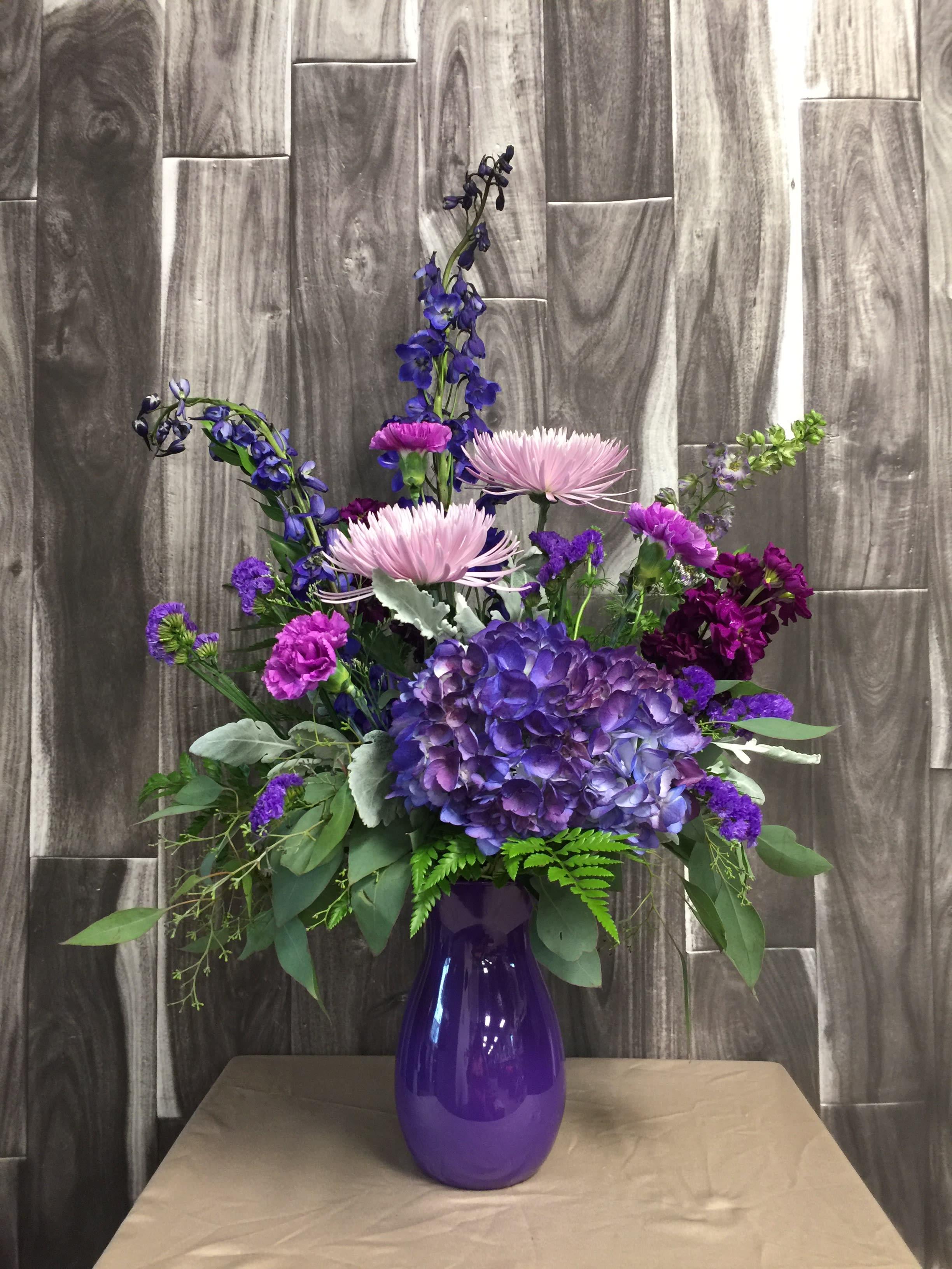 Purple Passion Purple Passion - Beautiful purple flowers including hydrangea, delphinium, stock and carnations adorn this bright purple vase!