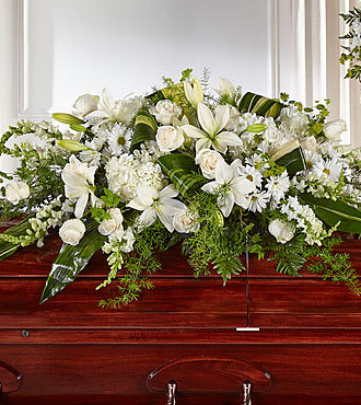 Abundance Casket Spray - White flowers with assorted greenery create a beautiful tribute with lilies, roses, snapdragons and daisies.
