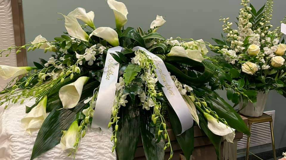White Orchid and Calla Casket spray White Orchid and Calla Casket spray - An elegant spray of Callas and white Orchids with mix greens for the Casket. *****Side piece in picture not included***