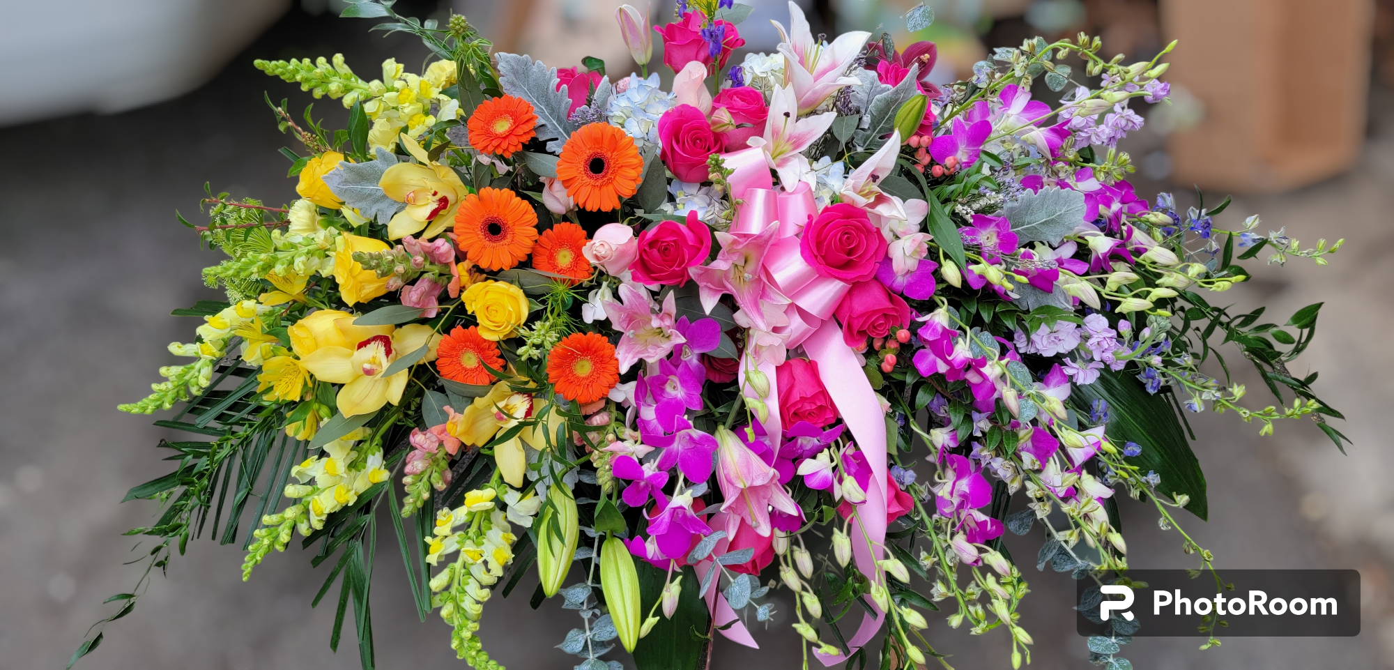 Sweet Memories Casket Spray Sweet Memories Casket Spray - The elegant arrangement includes hot pint dendrobium, yellow cymbidiums, hot pink roses, peach spray roses, pink stargazer lilies, peach miniature gerberas, green gladioli, yellow snapdragons, lavender stock and accented with assorted greenery.