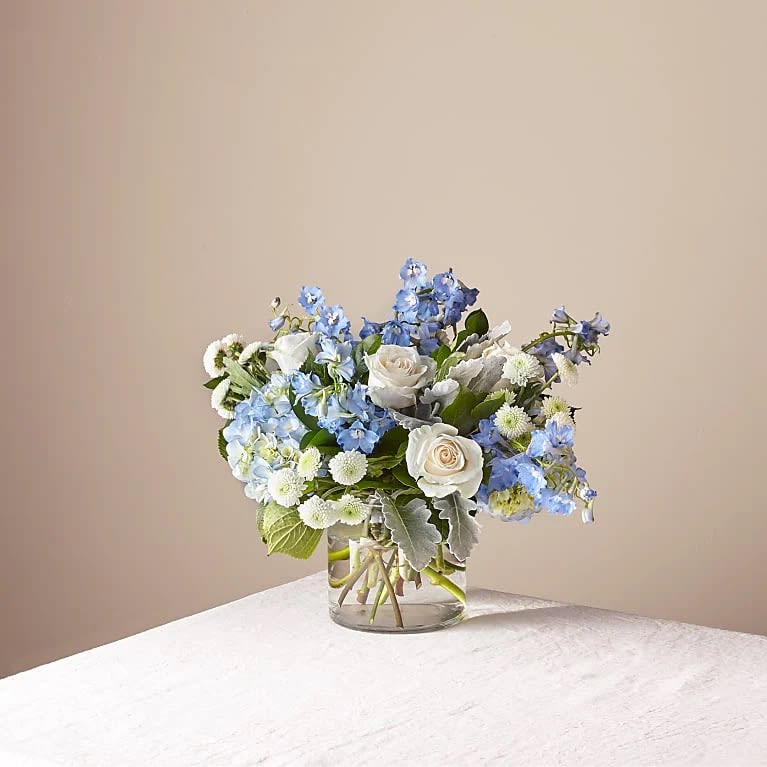 Clear Skies  - Experience a modern and unique floral arrangement that beautifully blends the sentiments of love, peace, and freedom. Our stoning design features a selection of blooms that come together in perfect harmony, creating a one-of-a-kind masterpiece that's sure to captivate and delight. With its eye-catching aesthetic and contemporary feel, this arrangement is perfect for anyone seeking a fresh and distinctive floral option. Whether you're sending a gift to a loved one, celebrating a special occasion, or simply treating yourself to something special, our stoning modern floral arrangement is the perfect choice. Order now and experience the beauty of love, peace, and freedom in a truly remarkable way!