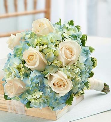 Blue and White Petite Bouquet - Stunning white roses, blue hydrangea, and variegated pittosporum create a charming smaller bouquet that's perfect for mother of the bride or groom, or as a toss-away bouquet. 