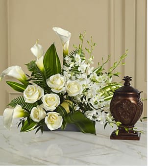 The FTD® At Peace™ Arrangement The FTD® At Peace™ Arrangement - This extraordinary mixed flower bouquet is an excellent choice for creating a beautiful, serene and reverential setting for an urn containing the cremated remains of the deceased. The asymmetrical arrangement is hand-arranged by a local FTD artisan florist and includes Dendrobium orchids, roses, calla lilies, and lush, complementary greenery in a low silvery plastic rectangular container. Beautiful on its own or to enhance a display of a meaningful memento, photograph or candle. Your purchase includes a complimentary personalized gift message.
