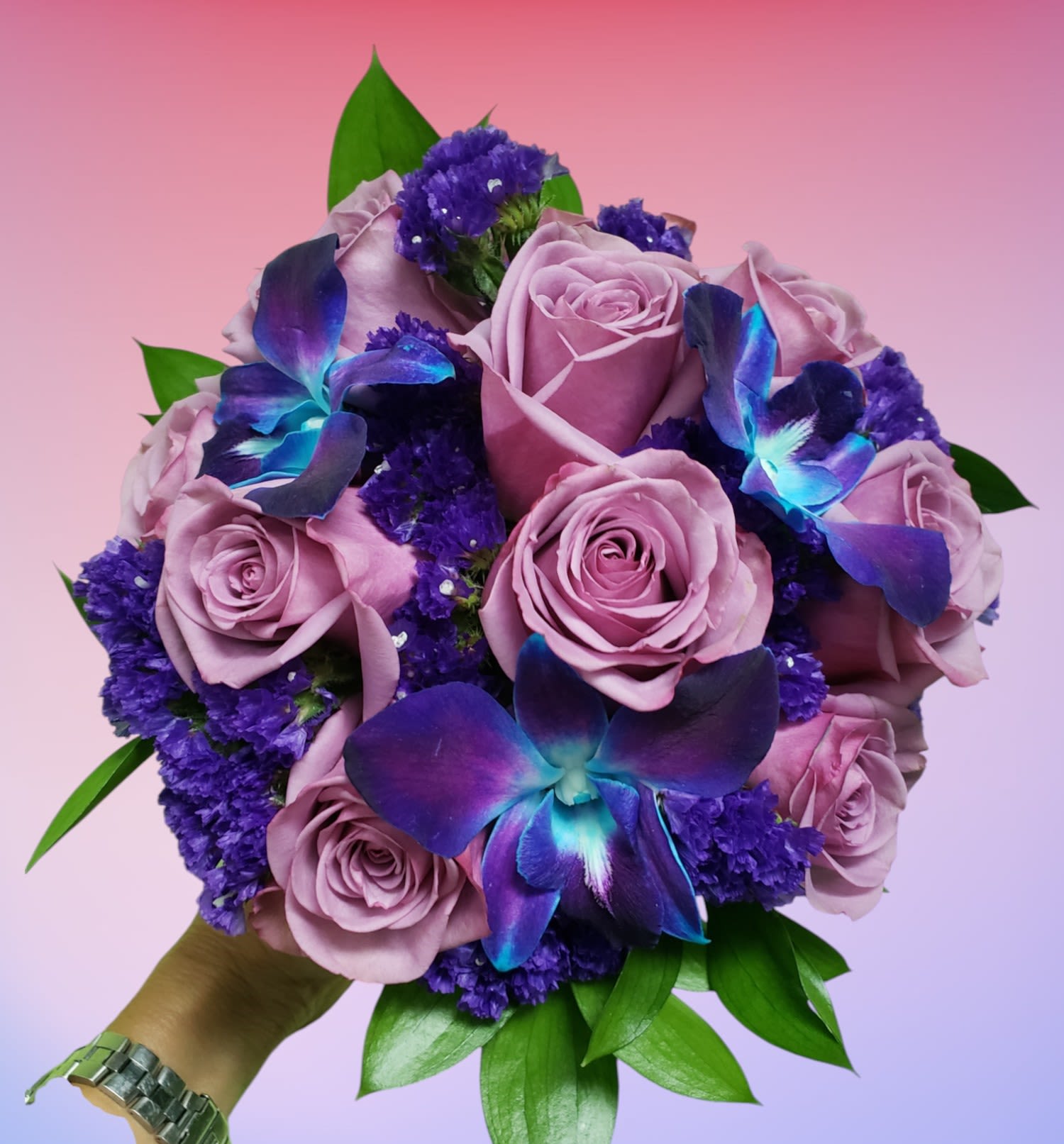 Purple Passion Wedding Bouquet - Lavender roses, Blue Bom Dendrobium Orchid blooms and purple statis filler are expertly designed with a touch of fresh greenery. This vibrant bouquet is so unique and bold.