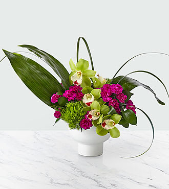 Pure Beauty  - The beauty of this bouquet is in its artful combination of orchids, green trick dianthus, carnations, aspidistra leaves and ruscus in a modern, white ceramic bowl.   Sure to turn heads wherever it's placed.