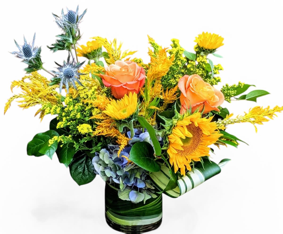 Amber Waves Amber Waves - Golden blooms and orange roses are complimented with blue thistles and hydrangea. A making for a delightful arrangement.