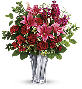 Sterling Love Bouquet - Sleek and chic, this sterling silver mirrored, blown glass vase adds a touch of modern luxury to this gorgeous bouquet of red roses and pink lilies.  Red roses, dark red spray roses, dark pink asiatic lilies, red alstroemeria, and burgundy stock are arranged with lemon leaf, huckleberry, and pitta negra