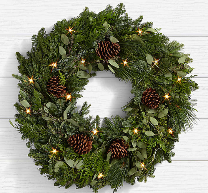 Winter Greetings Pine Wreath Winter Greetings Pine Wreath - WELCOME THE CHRISTMAS SPIRIT Greet the season and guests near and far with this festive wreath made with noble fir, pine cones, and holiday cheer.