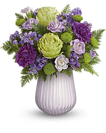 Sweetest Lavendar Bouquet - Sweet as can be, this pretty purple and green bouquet gets a stylish update from a sculpted glass vase with chic opaque finish.  This stunning flower arrangement features green roses, purple carnations, miniature lavender carnations, green button spray chrysanthemums and lavender sinuata statice arranged with leatherleaf fern. Delivered in a Sweetest Lavender Vase. Orientation: All-Around  SUBSTITUTION POLICY – Always deliver the freshest flowers! Please note the bouquet pictured reflects our original design.  If the exact flowers or container in this arrangement are not available, we will create a beautiful bouquet with the freshest available flowers.