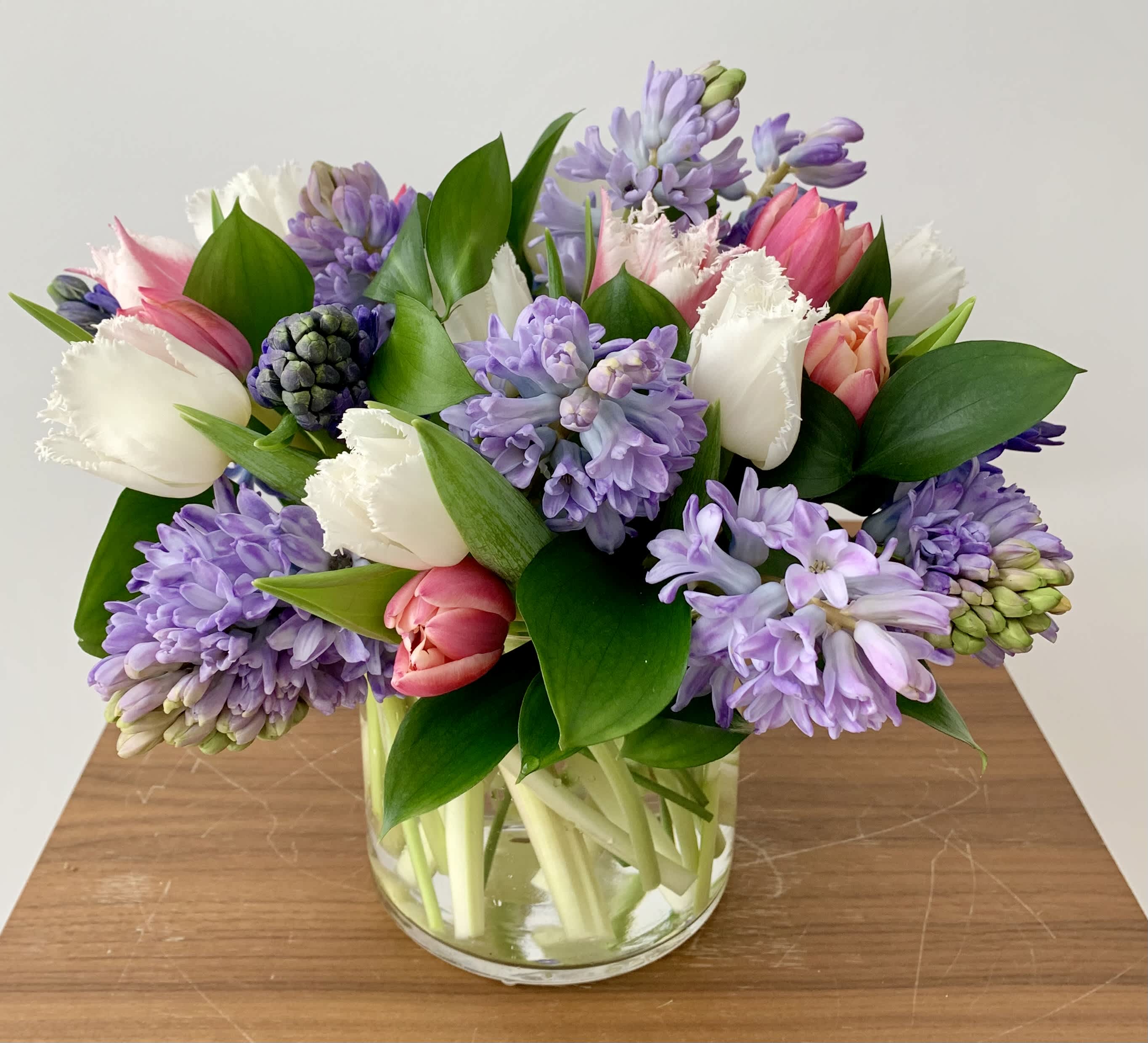 Hyacinths with Tulips - A simple elegant flower arrangement of fragrant hyacinths and tulips, with greenery mixed in. The color may vary or request your favorite color combination and I will do my best to accommodate your wish.