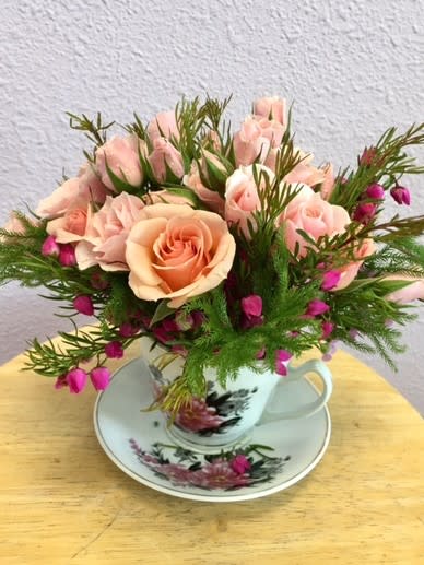 A Cup Of Tea by Forever Flowers A Cup Of Tea by Forever Flowers - A vintage styled arrangement in a cup of tea. Contains peach and light pink spray roses, greens & fillers.