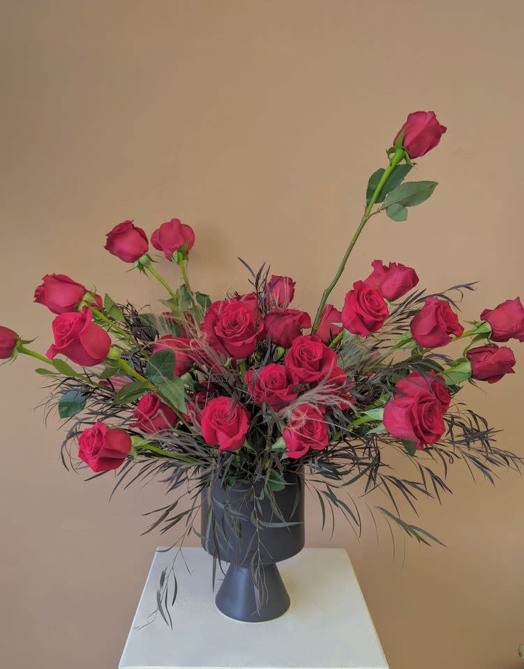 Roses are Red - A modern take on traditional red roses. Three dozen red roses asymmetrically arranged in a black ceramic vase. 