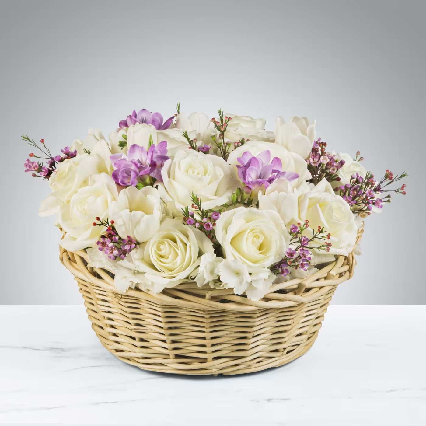 Basket of Joy by BloomNation™ Basket of Joy by BloomNation™ - When the breeze is warm and the flowers are blooming send Basket of Joy by BloomNation™. Cream roses and tulips with accent purple freesia make this spring in a wicker basket! Perfect for Easter, Passover, Mother's Day and as any spring party centerpiece. APPROXIMATE DIMENSIONS 16" W X 11" H
