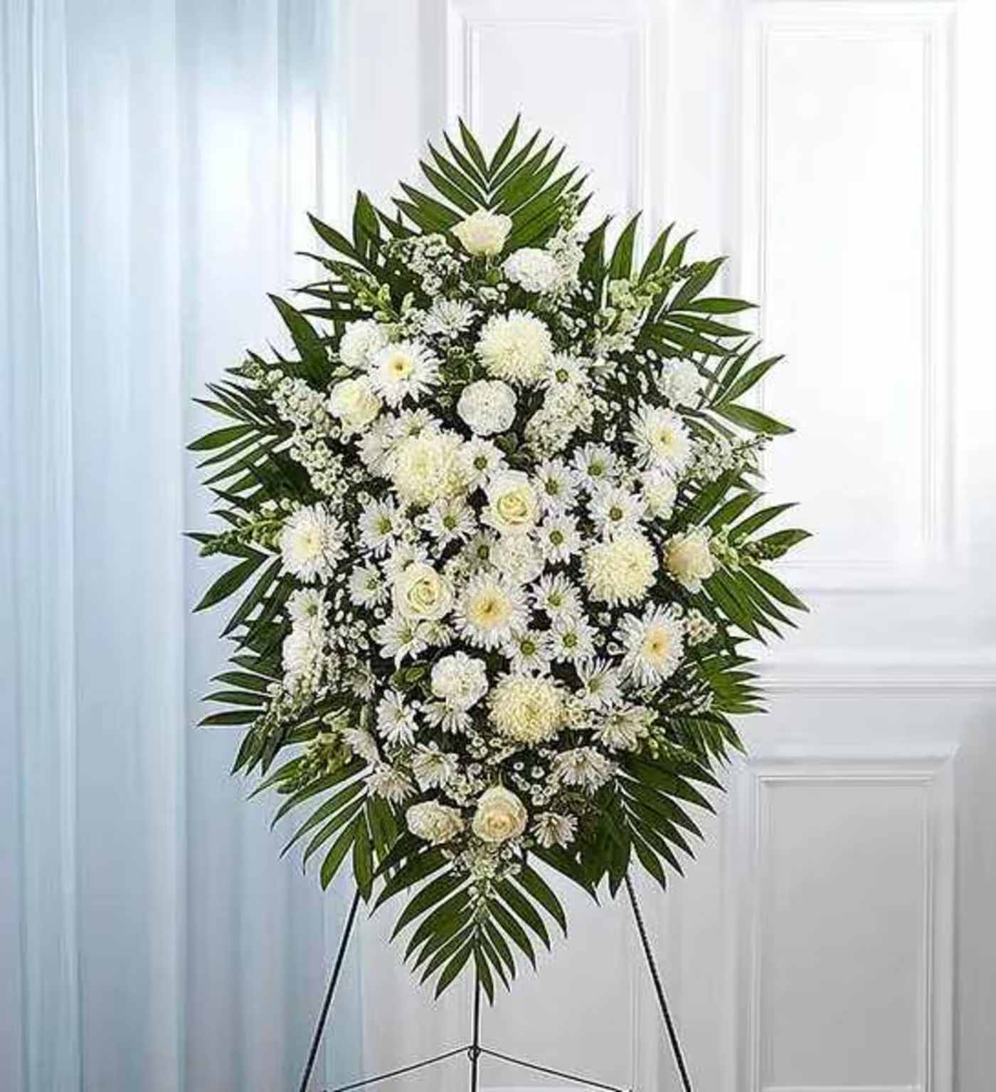 White Funeral Standing Spray - White flowers have a peacefulness and purity to them, bringing hope and light during a time of loss. Our impressive standing spray arrangement is meticulously handcrafted by expert local florists with an abundance of pristine white blooms for a lush, full presentation. Let it be a grand and memorable tribute to one who was loved so dearly.  All-white standing spray arrangement with roses, football mums, cremones, stock, snapdragons, carnations, daisy poms and monte casino; accented with soft, lush greenery Large measures approximately 56&quot;H x 38&quot;L without stand Medium measures approximately 46&quot;H x 34&quot;L without stand Small measures approximately 42&quot;H x 30&quot;L without stand Arrives on an easel Appropriate for the funeral home or gravesite Our florists hand-design each arrangement, so varieties may vary due to local availability