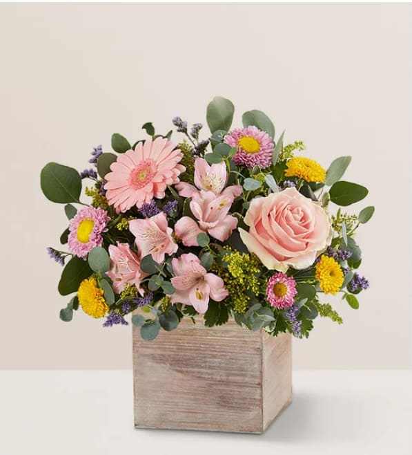 Spring Sentiment™  - Spring is a time to refresh and reach out. Our spring bouquet celebrates that sentiment. Pastel pink and yellow blooms are loosely gathered with lush greenery for style and texture. Designed in our rustic, gray-washed wooden cube, it’s a gift that delivers on your feelings in the most beautiful way.  Product Details:  All-around arrangement with pink roses, mini Gerbera daisies, Matsumoto asters, and Peruvian lilies (alstroemerias); yellow button poms; purple limonium; and assorted greenery Artistically designed in our rustic wood-grain cube container measuring 5&quot;W x 5&quot;L Large arrangement measures approximately 11&quot;H x 11&quot;W Medium arrangement measures approximately 10&quot;H x 10&quot;W Small arrangement measures approximately 9&quot;H x 9&quot;W Our florists hand-design each arrangement, so colors and varieties may vary due to local availability To ensure lasting beauty, Peruvian lilies arrive in bud form, ready to bloom in a few days