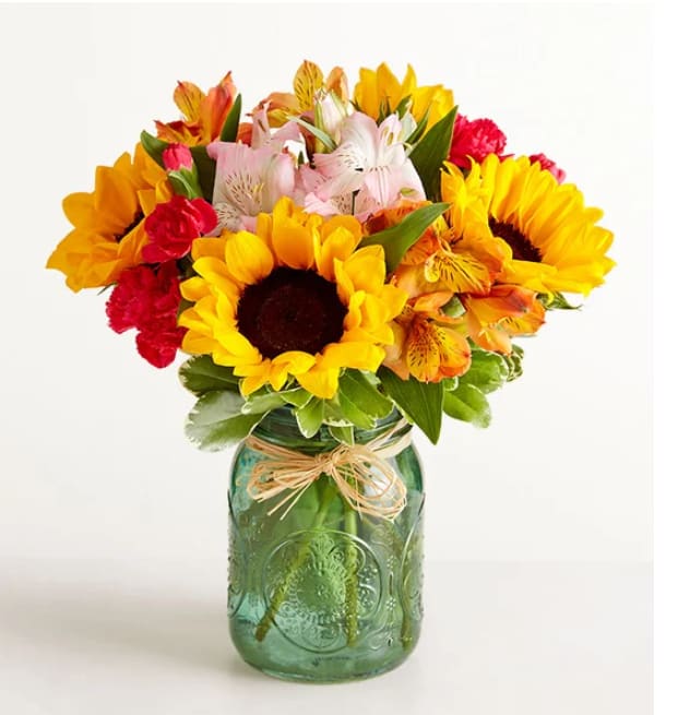 Warm Sunset Warm Sunset - Like a warm, radiant sunset, our sunflower bouquet is even more memorable when shared with someone you care about. Golden yellow sunflowers are gathered with pink and orange blooms, capturing the carefree spirit of a summer evening. Mixed bouquet of sunflowers, hot-pink mini carnations, and pink and orange or red Peruvian lilies (alstroemeria), accented with assorted greenery Shipped fresh from our premier farms around the world, our flowers are cared for every step of the way to ensure lasting beauty and enjoyment Peruvian lilies may arrive in bud form and will fully bloom over the next few days