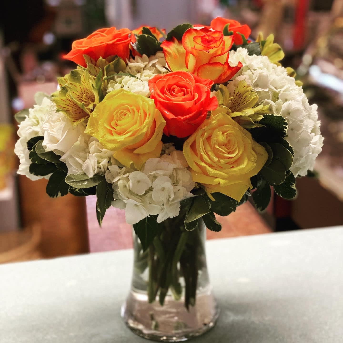 A Beautiful Sunshine Day A Beautiful Sunshine Day - Yellow Roses, Orange Roses, Two-Tone High & Magic Roses, White Hydrangea, Yellow Alstroemeria in a glass gathering vase